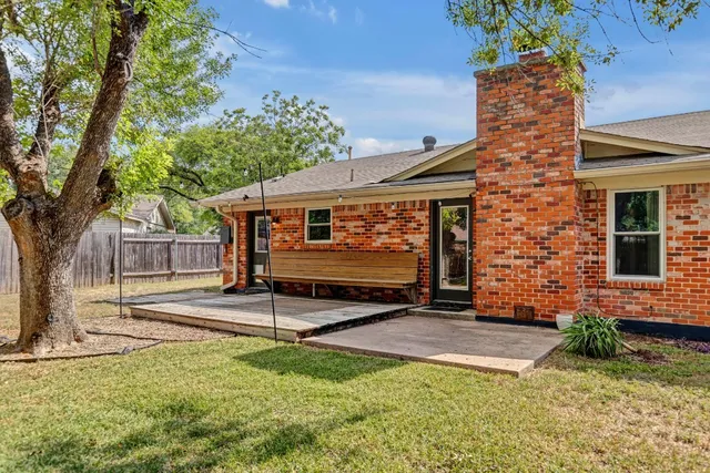a view of a house with backyard and a tree