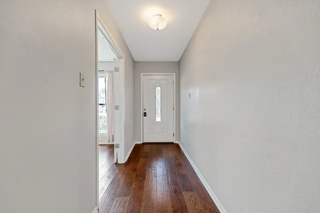 a view of a hallway with wooden floor