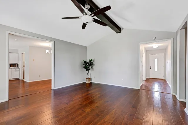 a view of empty room with wooden floor