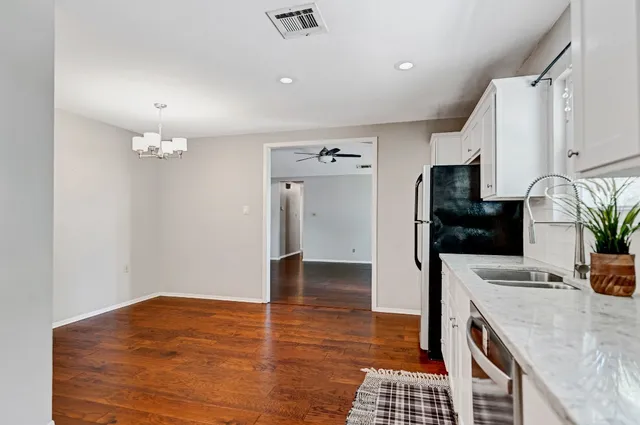 a kitchen with granite countertop a refrigerator and a stove top oven