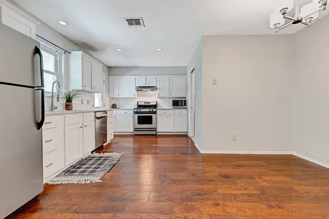 a kitchen with granite countertop a sink cabinets and stainless steel appliances