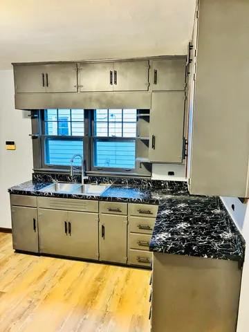 a kitchen with granite countertop a stove and a sink