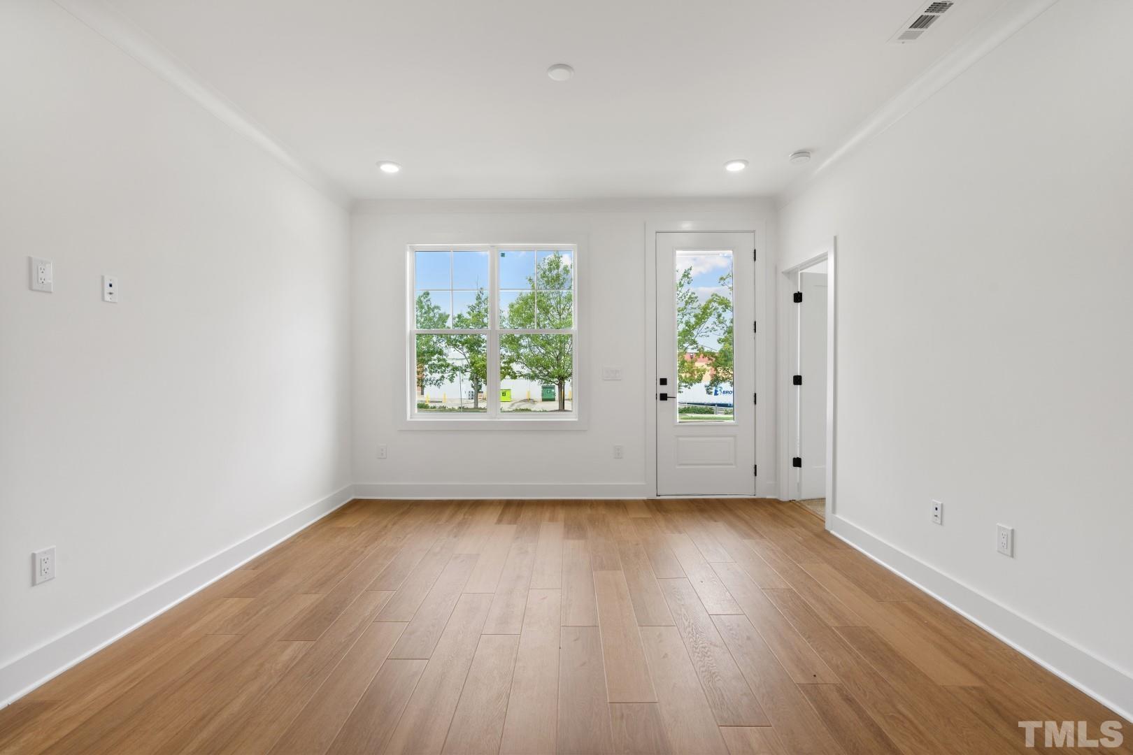6118 Fox Road Raleigh, NC 27616 - Photo 14 of 32 an empty room with wooden floor and windows