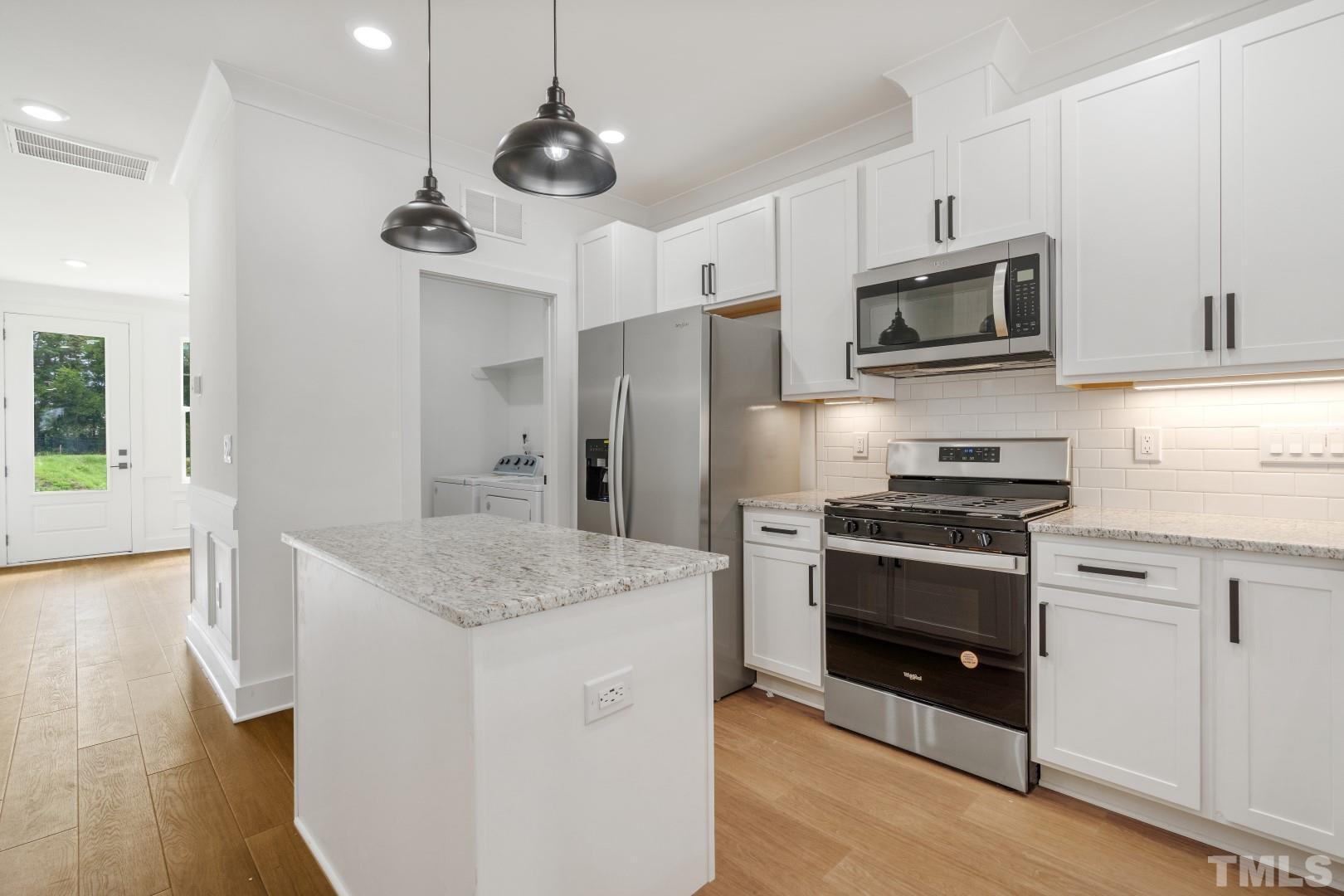 6118 Fox Road Raleigh, NC 27616 - Photo 9 of 32 a kitchen with stainless steel appliances granite countertop a sink a stove and a refrigerator