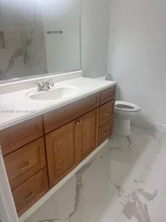 a bathroom with a sink a toilet and mirror