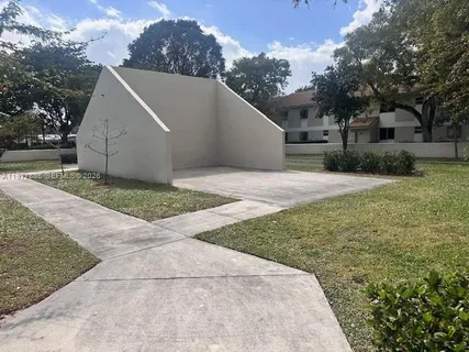 a view of backyard with large tree and wooden fence