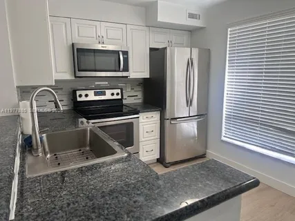 a kitchen with a stove a microwave and a refrigerator