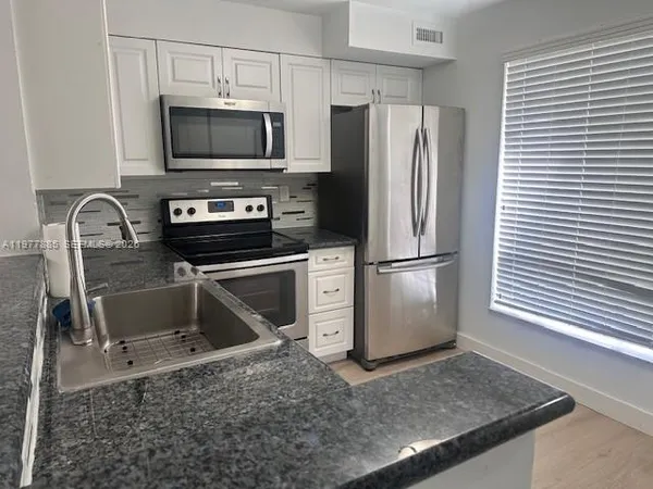 a kitchen with a stove a microwave and a refrigerator