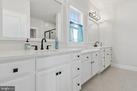 a bathroom with double sink and a mirror