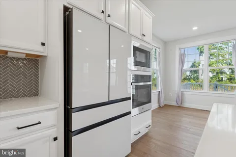 a kitchen with stainless steel appliances a refrigerator and a window