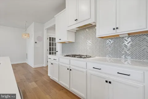 a kitchen with white cabinets and white appliances