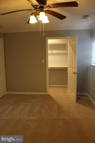 an empty room with a empty space and a ceiling fan