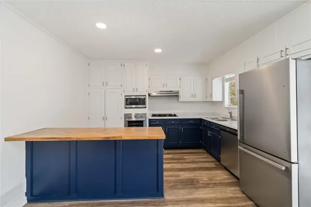 a kitchen with stainless steel appliances granite countertop a refrigerator and a stove
