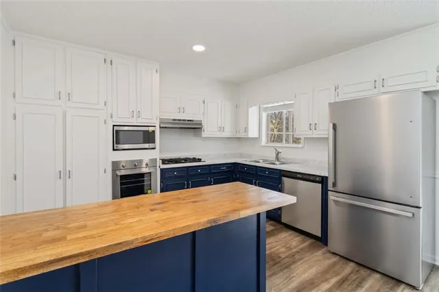 a kitchen with stainless steel appliances granite countertop a refrigerator sink and cabinets
