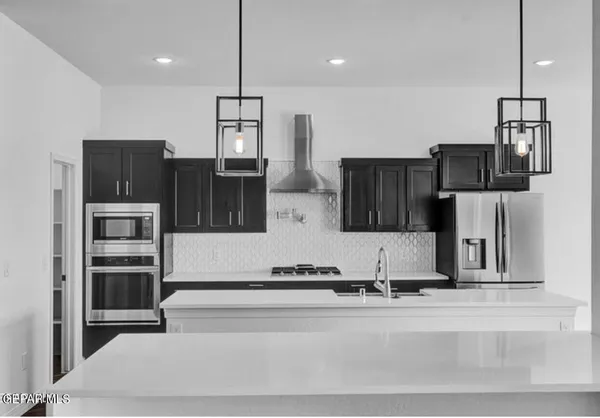 a kitchen with stainless steel appliances kitchen island a refrigerator and microwave