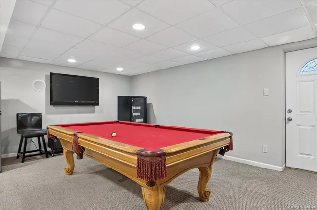 a living room with a flat screen tv and pool table