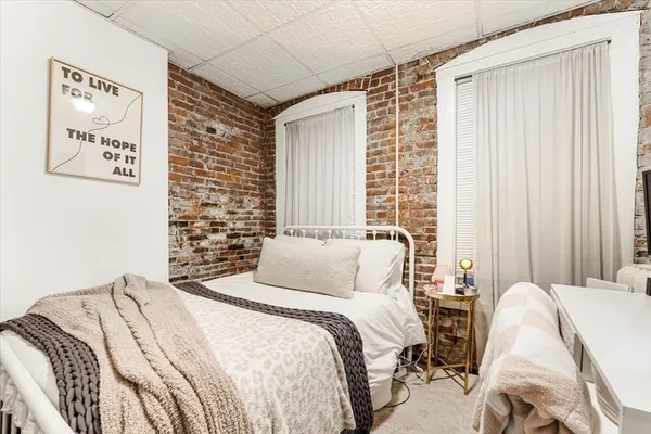 a bedroom with a bed and a painting on the wall