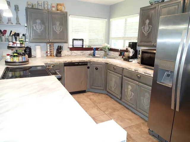 a kitchen with a sink refrigerator and window