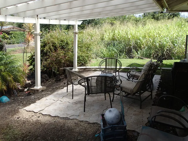 a patio with table and chairs and potted plants
