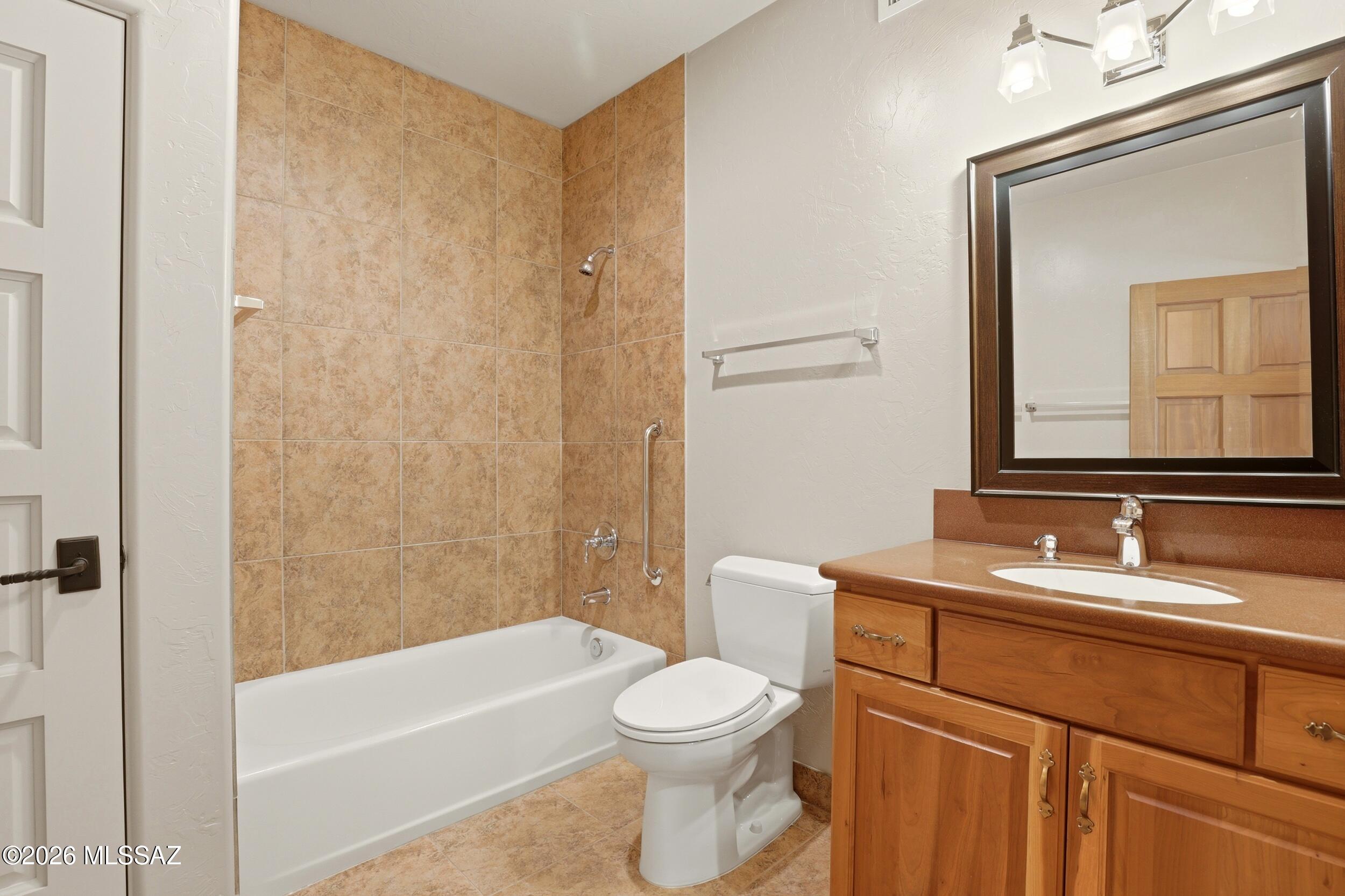 6331 West Trails End Road Tucson, AZ 85745 - Photo 26 of 41 a bathroom with a toilet a sink a mirror and shower