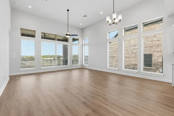 a view of a livingroom with wooden floor kitchen view and a window