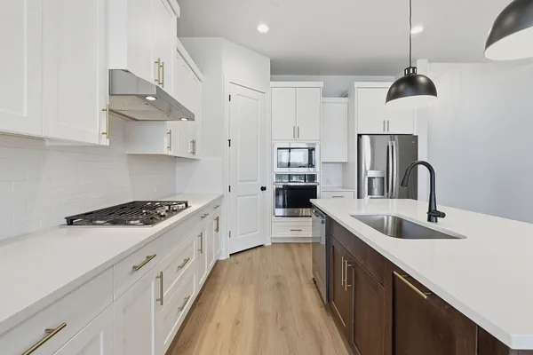 a kitchen with stainless steel appliances a sink stove and refrigerator