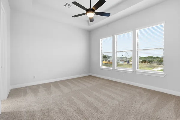 an empty room with a window and a fan