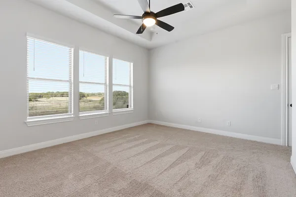 an empty room with a window and a fan