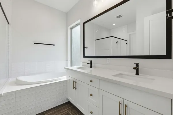 a bathroom with a bathtub a sink and a mirror