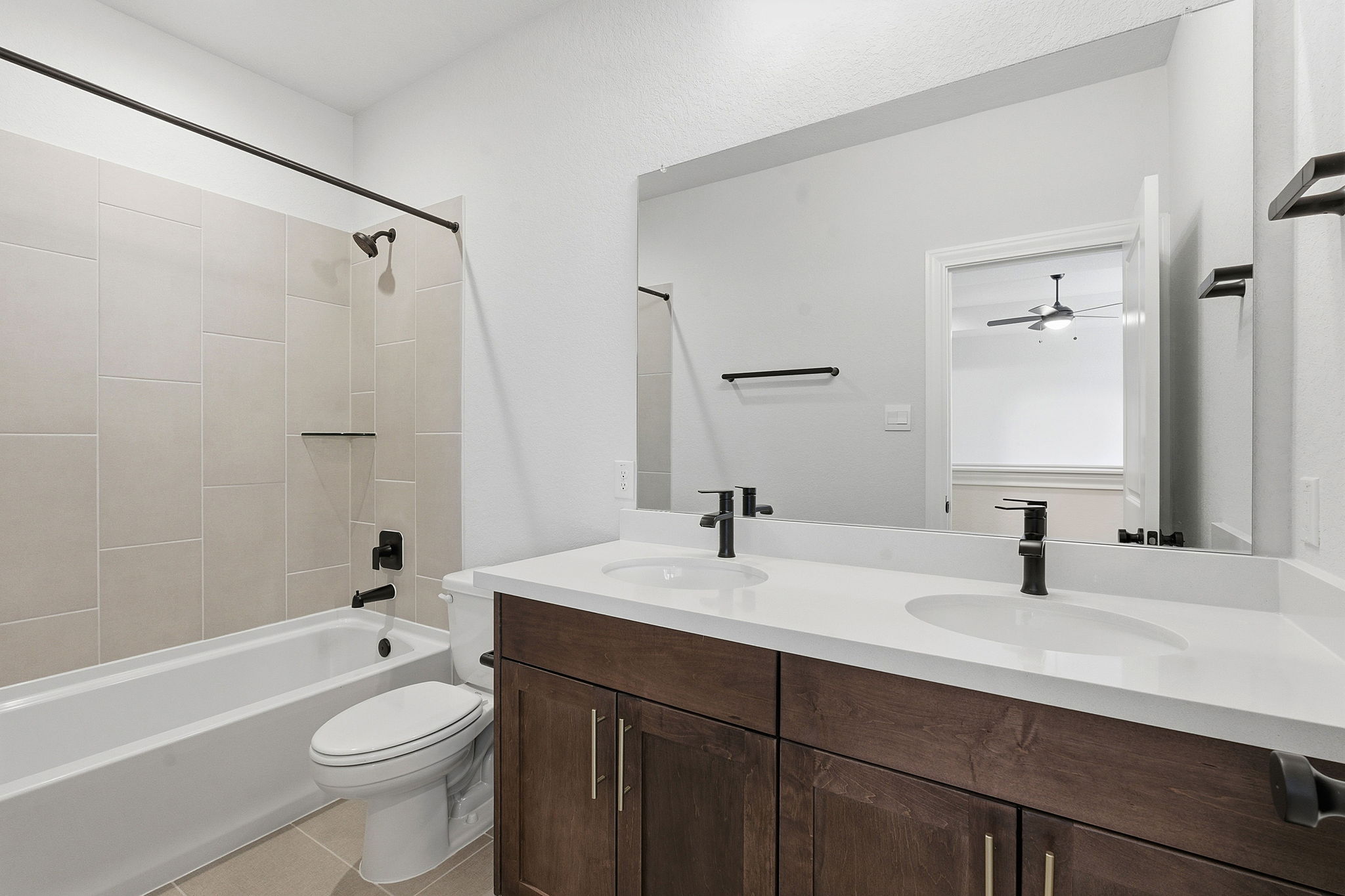 276 Prickly Poppy Loop Kyle, TX 78640 - Photo 30 of 38 Full bathroom with double vanity, shower combination, and light tile patterned floors