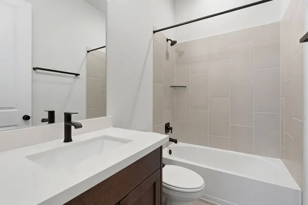 a bathroom with a sink a toilet a mirror and shower