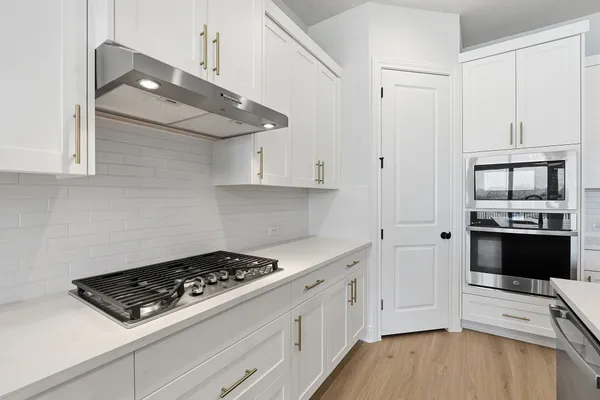 a kitchen with stainless steel appliances a white stove top oven and a wooden floors