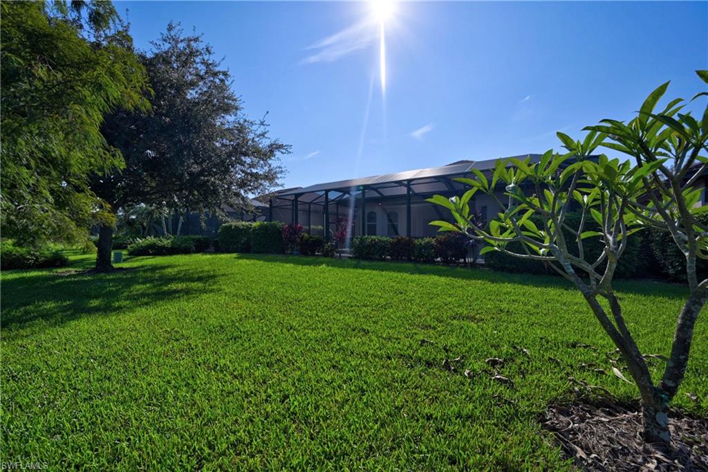 12518 Grandezza Circle Estero, FL 33928 - Photo 17 of 33 a view of a backyard with potted plants and large trees