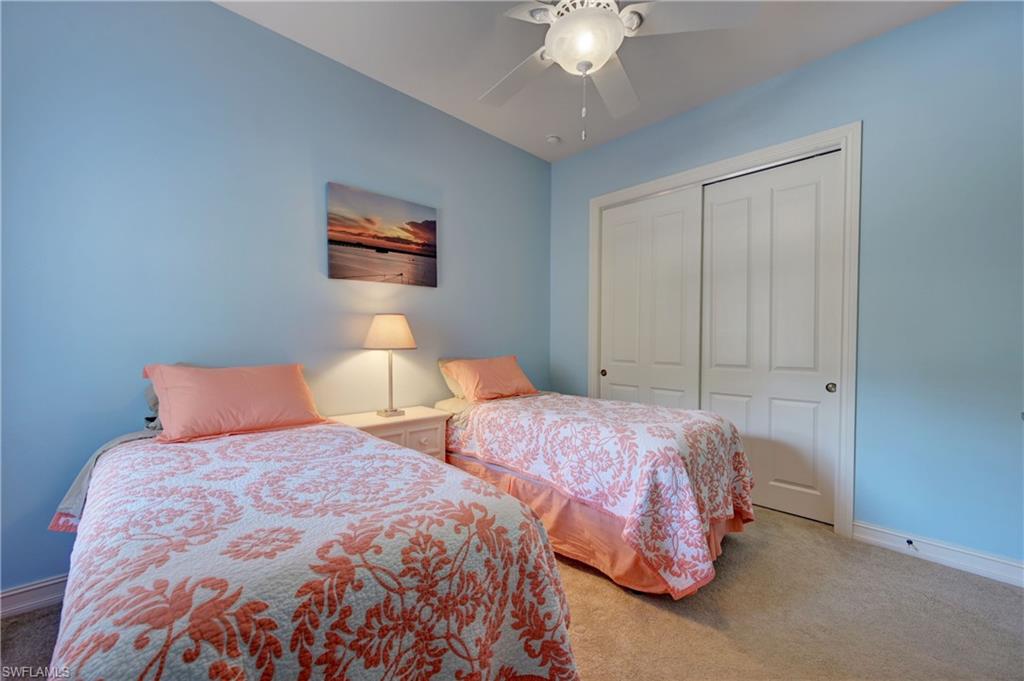 12518 Grandezza Circle Estero, FL 33928 - Photo 27 of 33 a bedroom with two beds and a chandelier