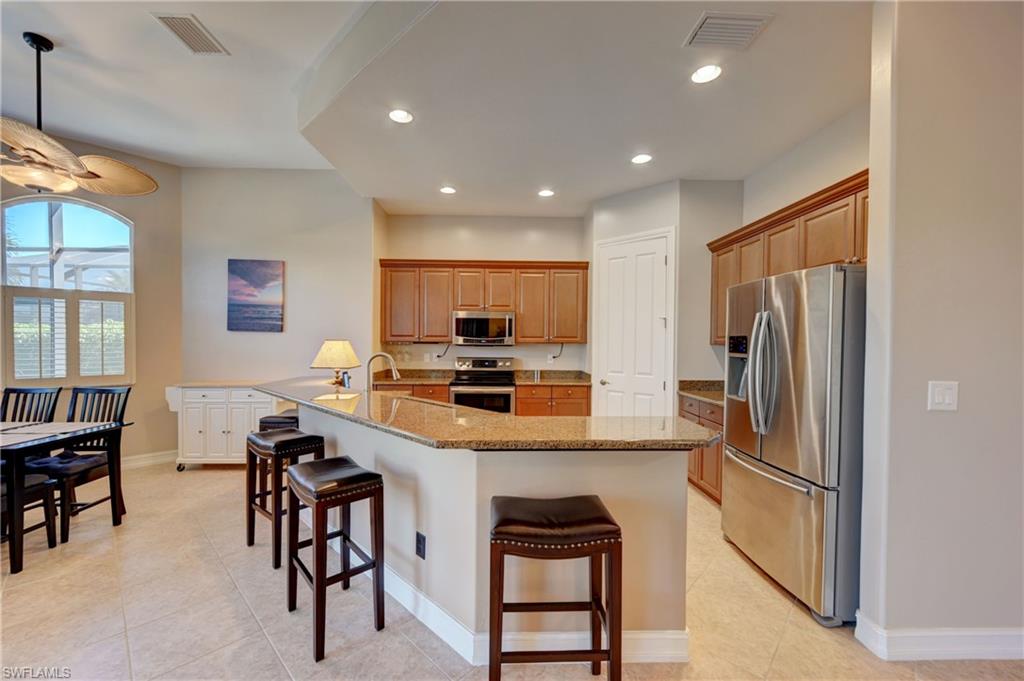 12518 Grandezza Circle Estero, FL 33928 - Photo 7 of 33 a kitchen with kitchen island a appliances a counter space and a refrigerator