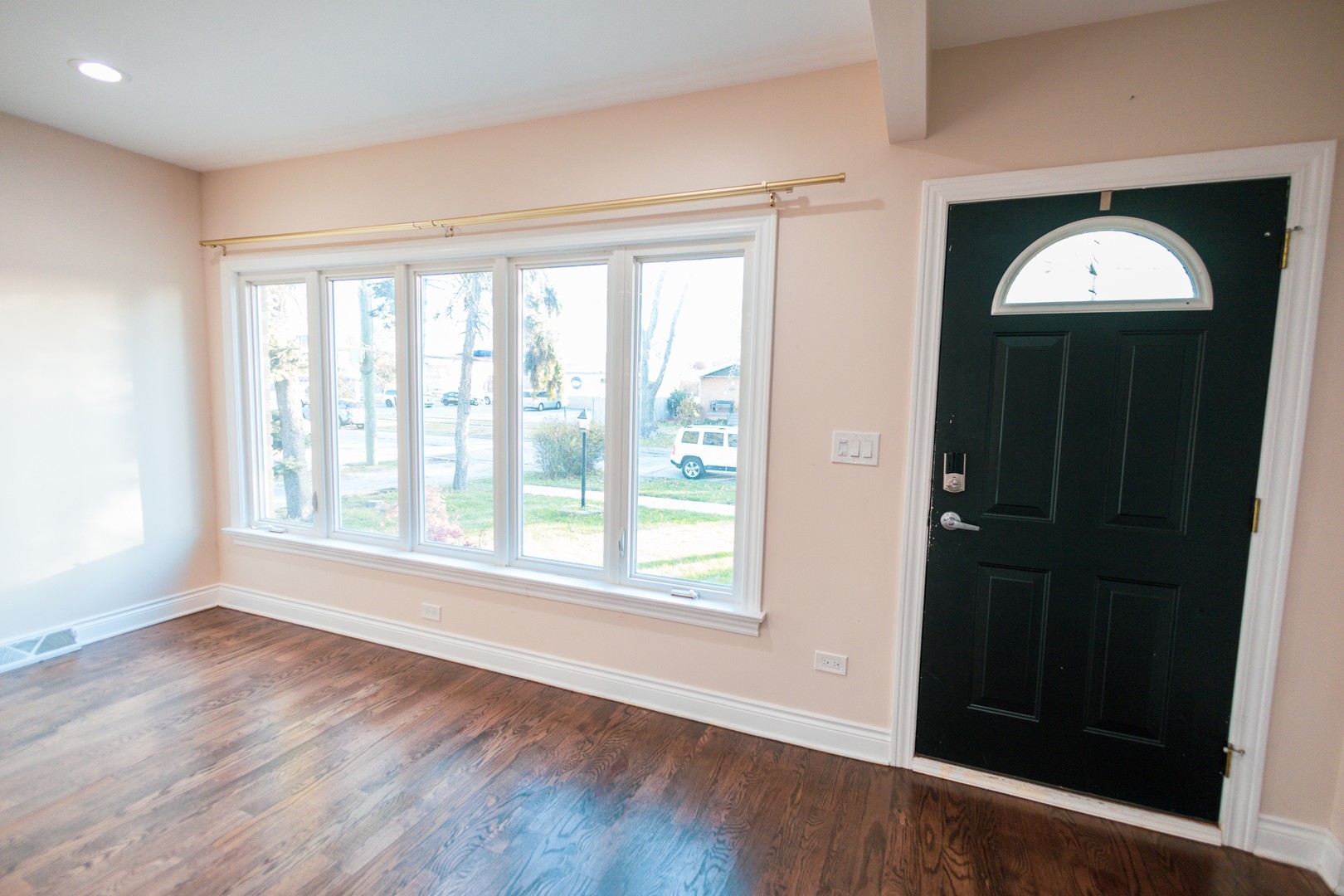 7916 McVicker Avenue Burbank, IL 60459 - Photo 2 of 19 an empty room with wooden floor cabinet and windows