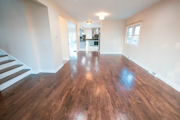 a view of a kitchen with wooden floor and a window