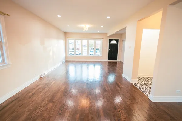 a view of livingroom with an entryway and wooden floor