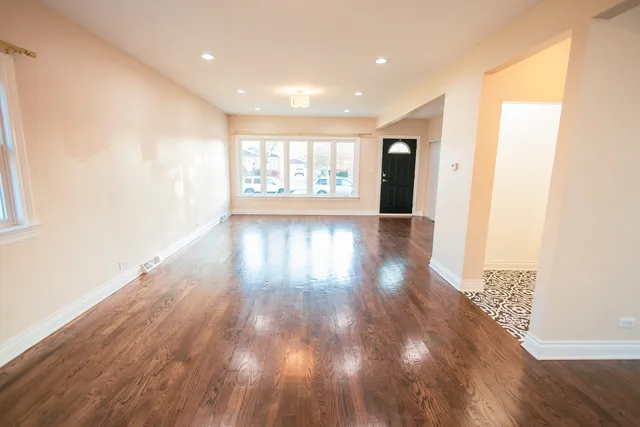 a view of livingroom with an entryway and wooden floor