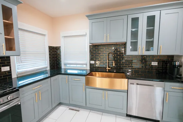a kitchen with granite countertop a sink and white cabinets