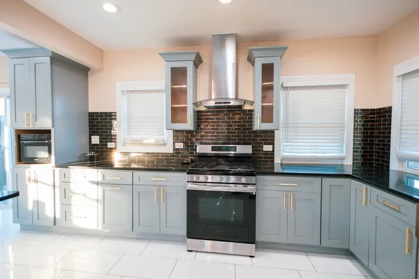 a kitchen with stainless steel appliances granite countertop a stove sink and cabinets