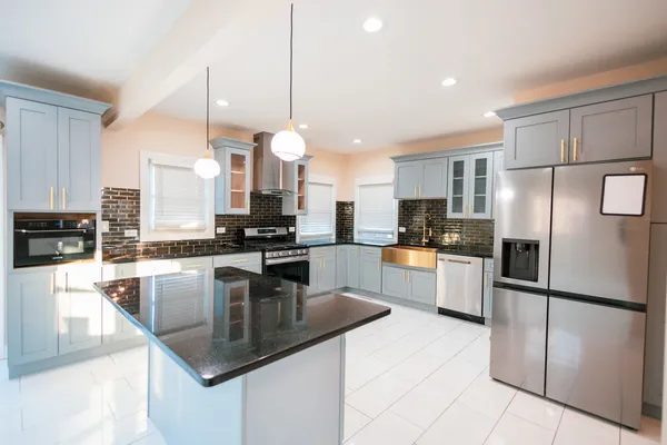 a kitchen with granite countertop a center island stainless steel appliances and cabinets