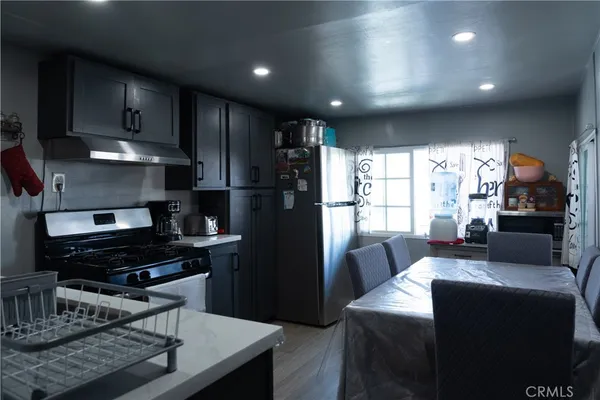a kitchen with a refrigerator and a stove top open