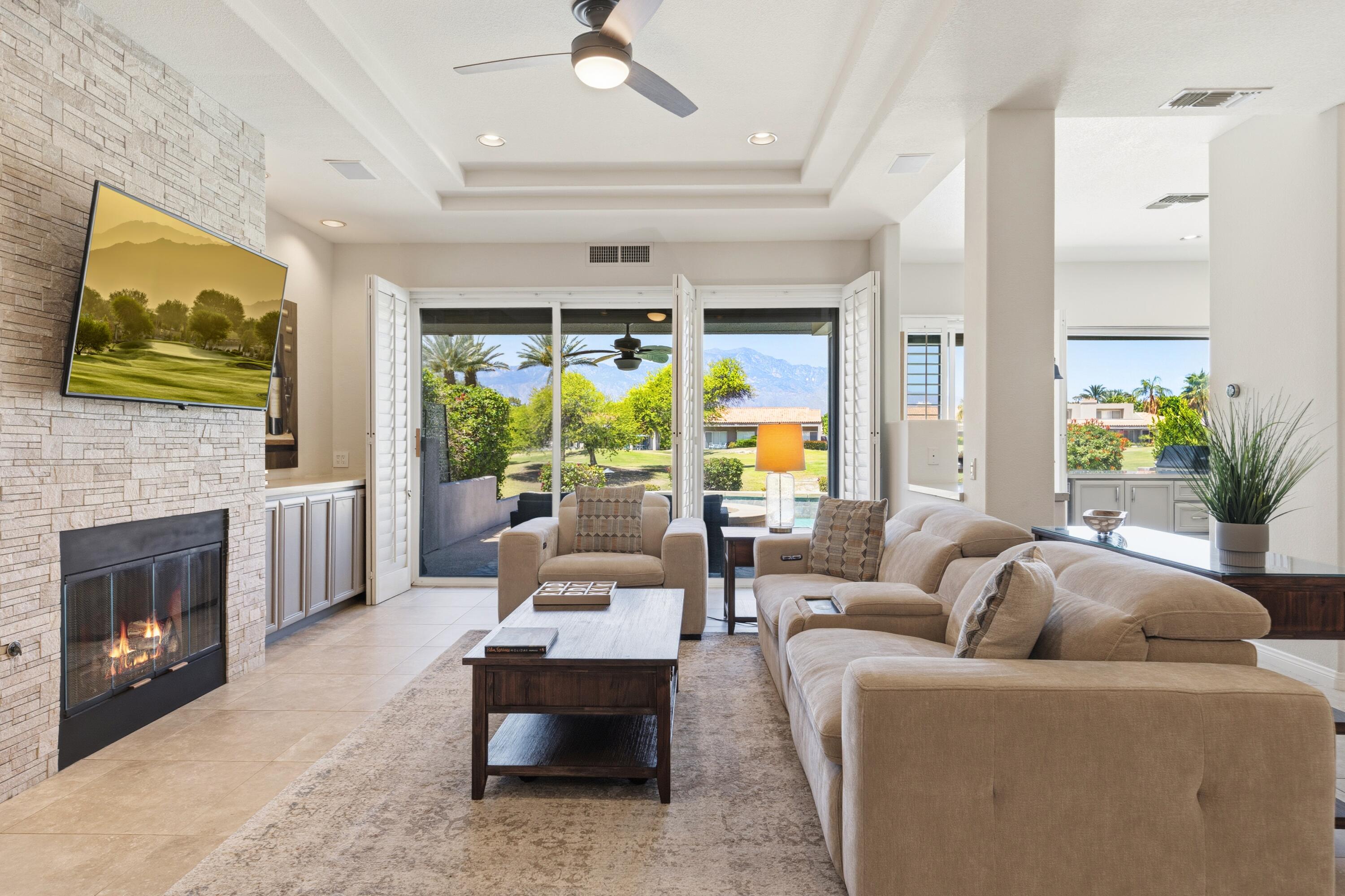 39 Augusta Drive Rancho Mirage, CA 92270 - Photo 9 of 53 a living room with furniture a fireplace and a flat screen tv
