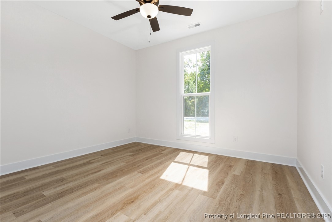 Tbd Doe Hill Road Autryville, NC 28318 - Photo 32 of 44 an empty room with wooden floor chandelier fan and windows