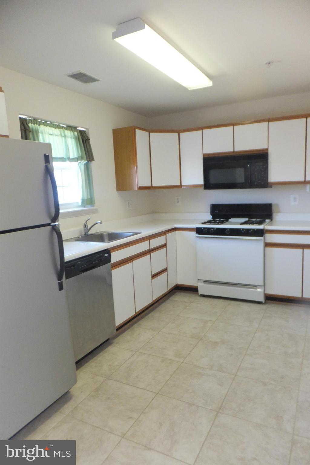 655 Constellation Square Southeast, Unit B Leesburg, VA 20175 - Photo 5 of 13 a kitchen with stainless steel appliances granite countertop a sink a stove a microwave a counter top and view living room