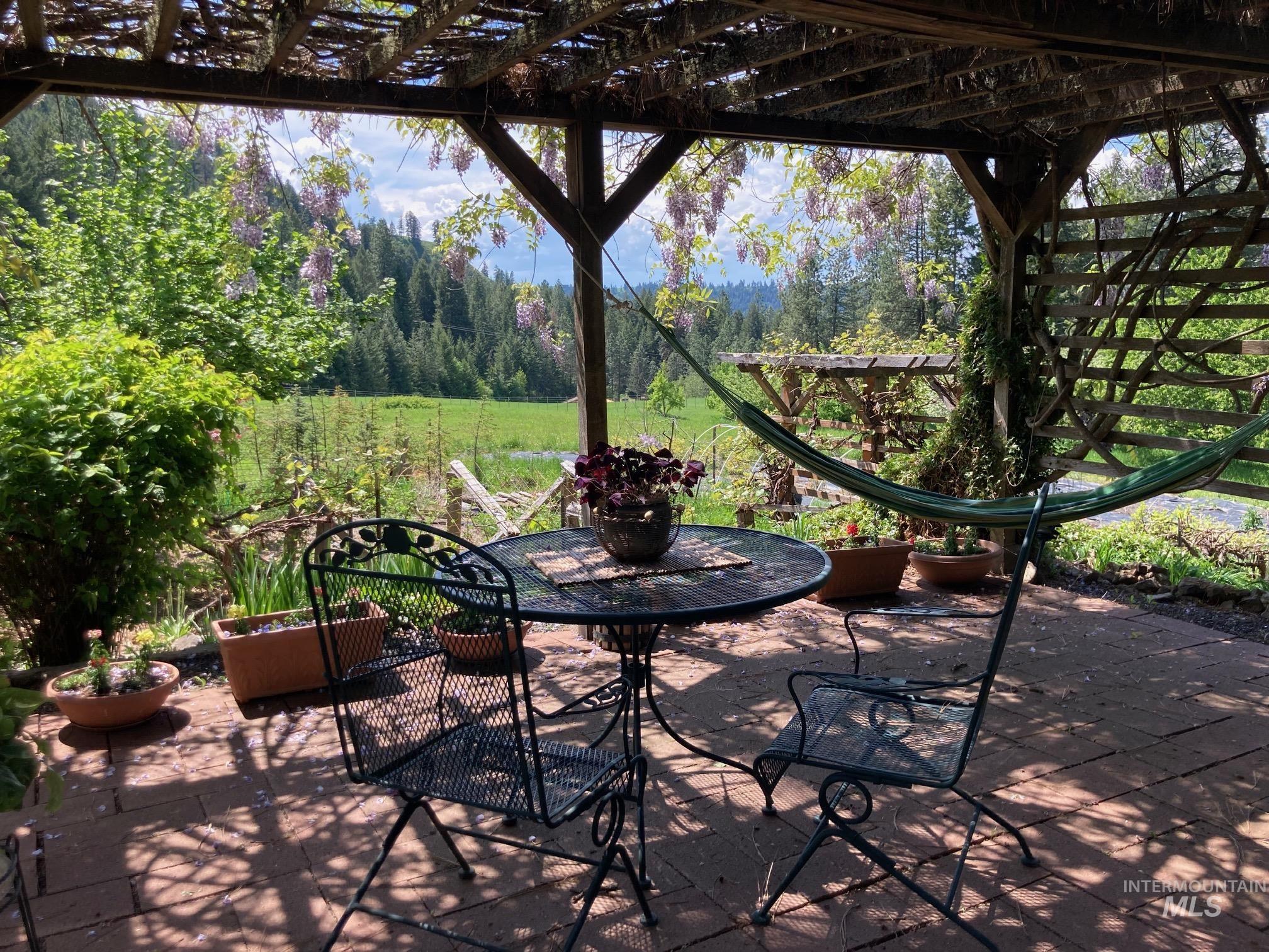 266 Falcon Ridge Road Kooskia, ID 83539 - Photo 40 of 50 Covered patio featuring a wood pergola with climbing vines, a paver stone surface, and expansive natural scenery