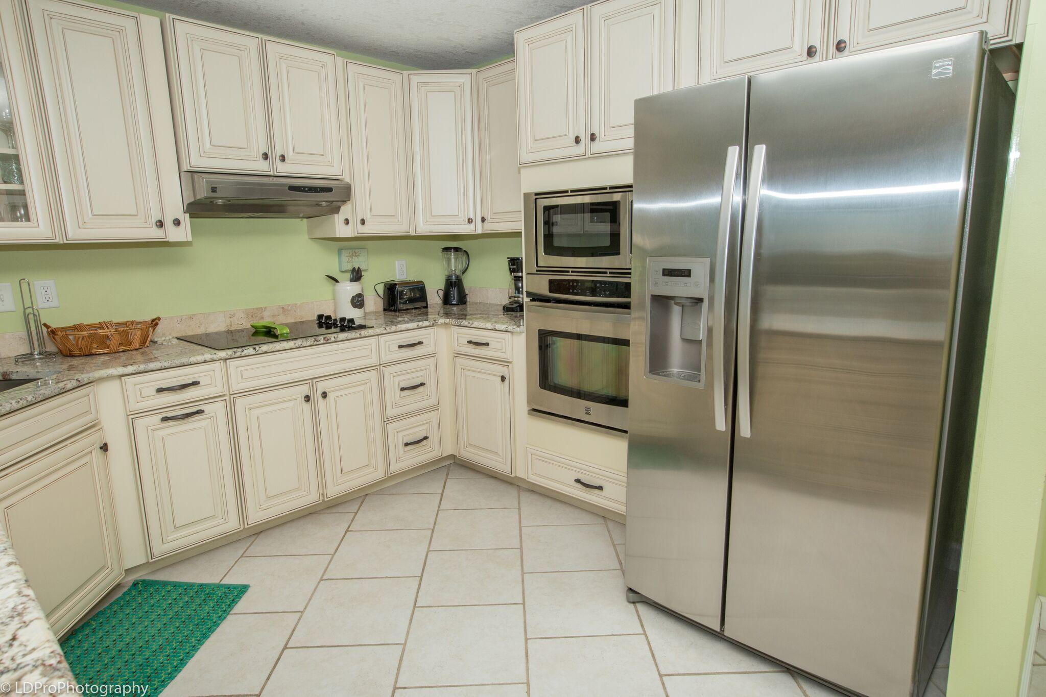 30 Moreno Point Road, Unit 601A Destin, FL 32541 - Photo 14 of 32 a kitchen with cabinets and stainless steel appliances