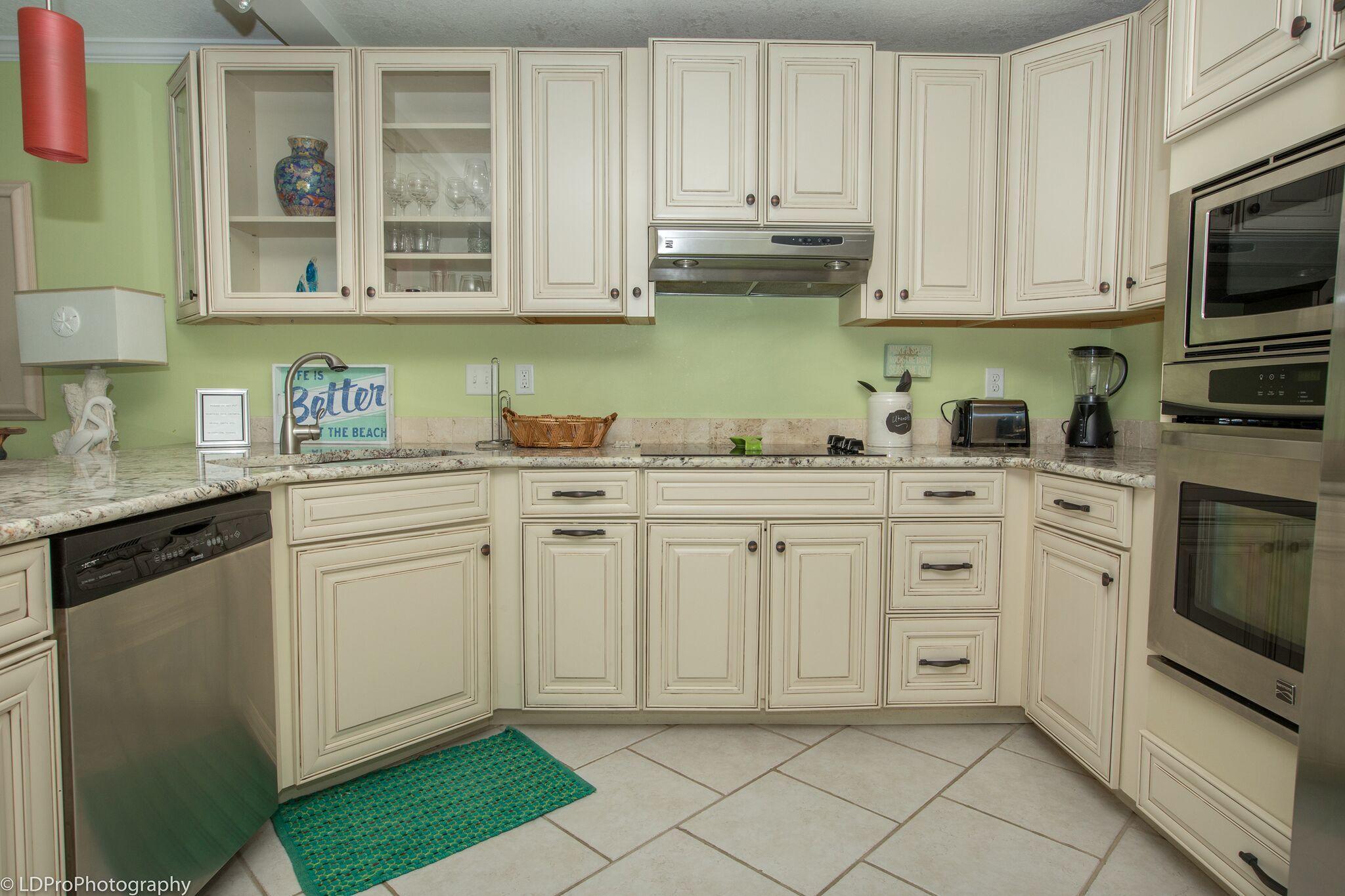 30 Moreno Point Road, Unit 601A Destin, FL 32541 - Photo 15 of 32 a kitchen with stainless steel appliances white cabinets and a stove top oven