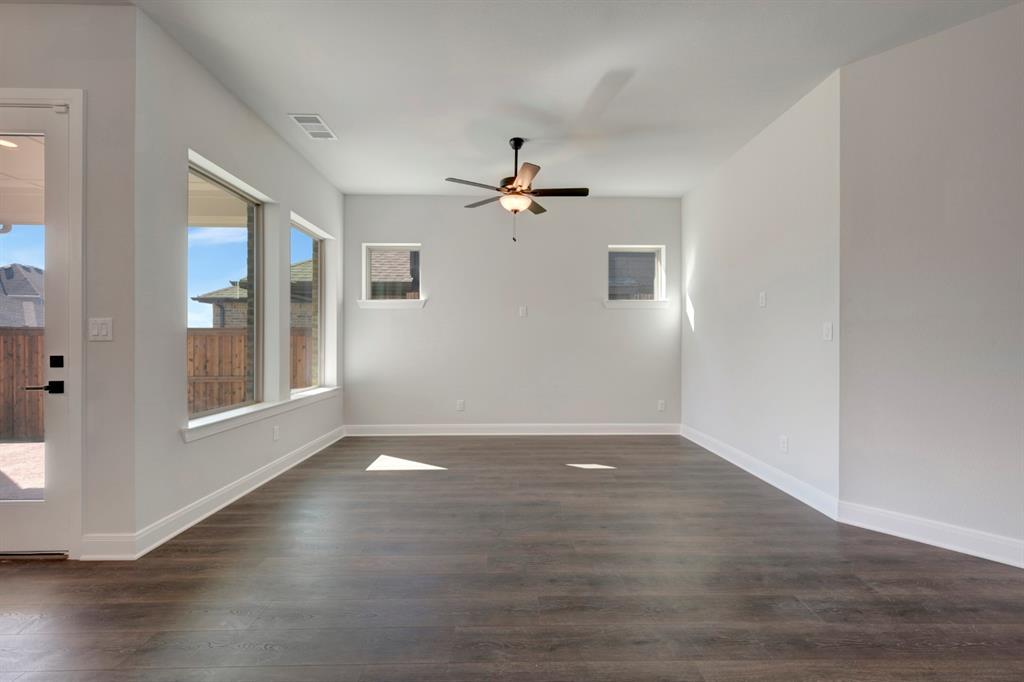 1857 Lightner Road Van Alstyne, TX 75495 - Photo 23 of 29 an empty room with wooden floor chandelier fan and windows